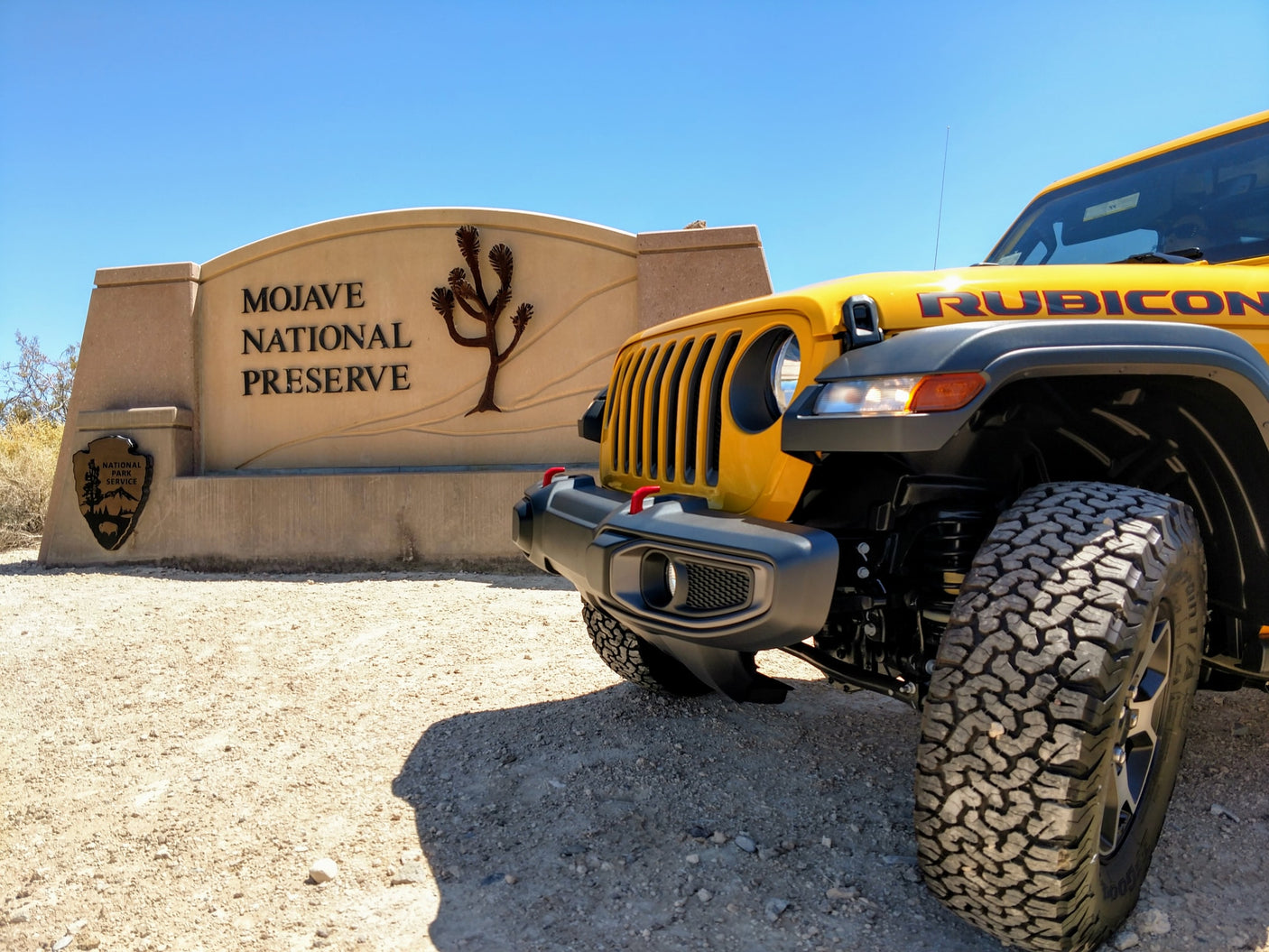 parked by a clear stream reflecting its image and surrounding forest. Ideal for an rv rental outdoor trip.|Yellow Jeep Wrangler Rubicon with rooftop tent on a scenic mountain off-road trail. Perfect for RV rental adventures!|A yellow Jeep Rubicon