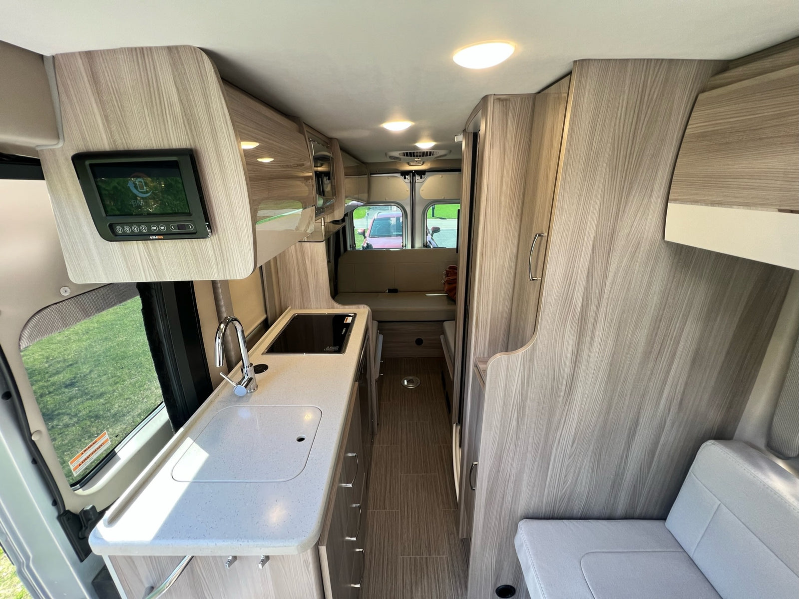 surrounded by trees with Spanish moss and a picnic area.|A silver "Sequence" RV rental with a pop-top