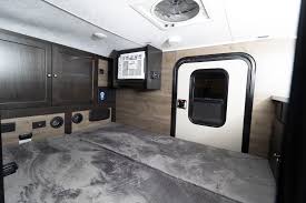ready for an RV rental adventure. This compact travel trailer is parked on dirt in a forest.|RV rental interior: Spacious floor for sleeping/cargo — photo 3