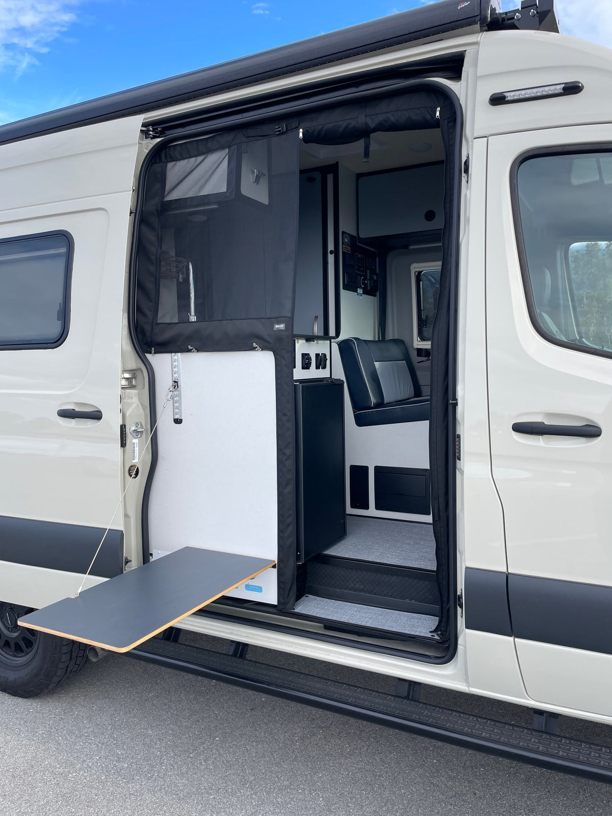 White camper van RV rental, side door open showing interior, mesh screen, and pull-out table for outdoor living. — photo 6