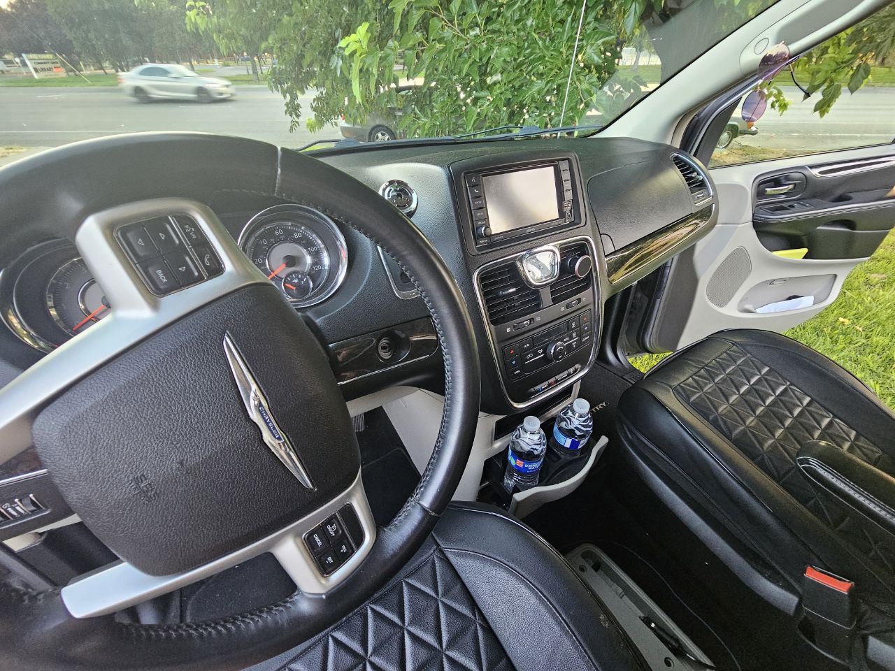 Experience comfort in this RV rental! Driver's view of a clean dashboard, steering wheel, and quilted seats for your trip.