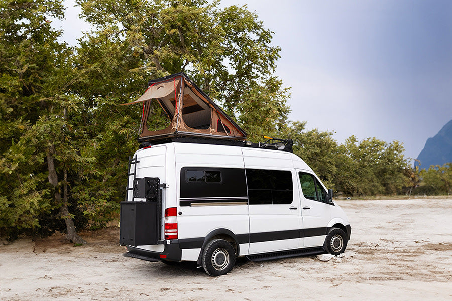 This white camper van with a rooftop tent and rear gear mount is ready for your next rv rental outdoor adventure.