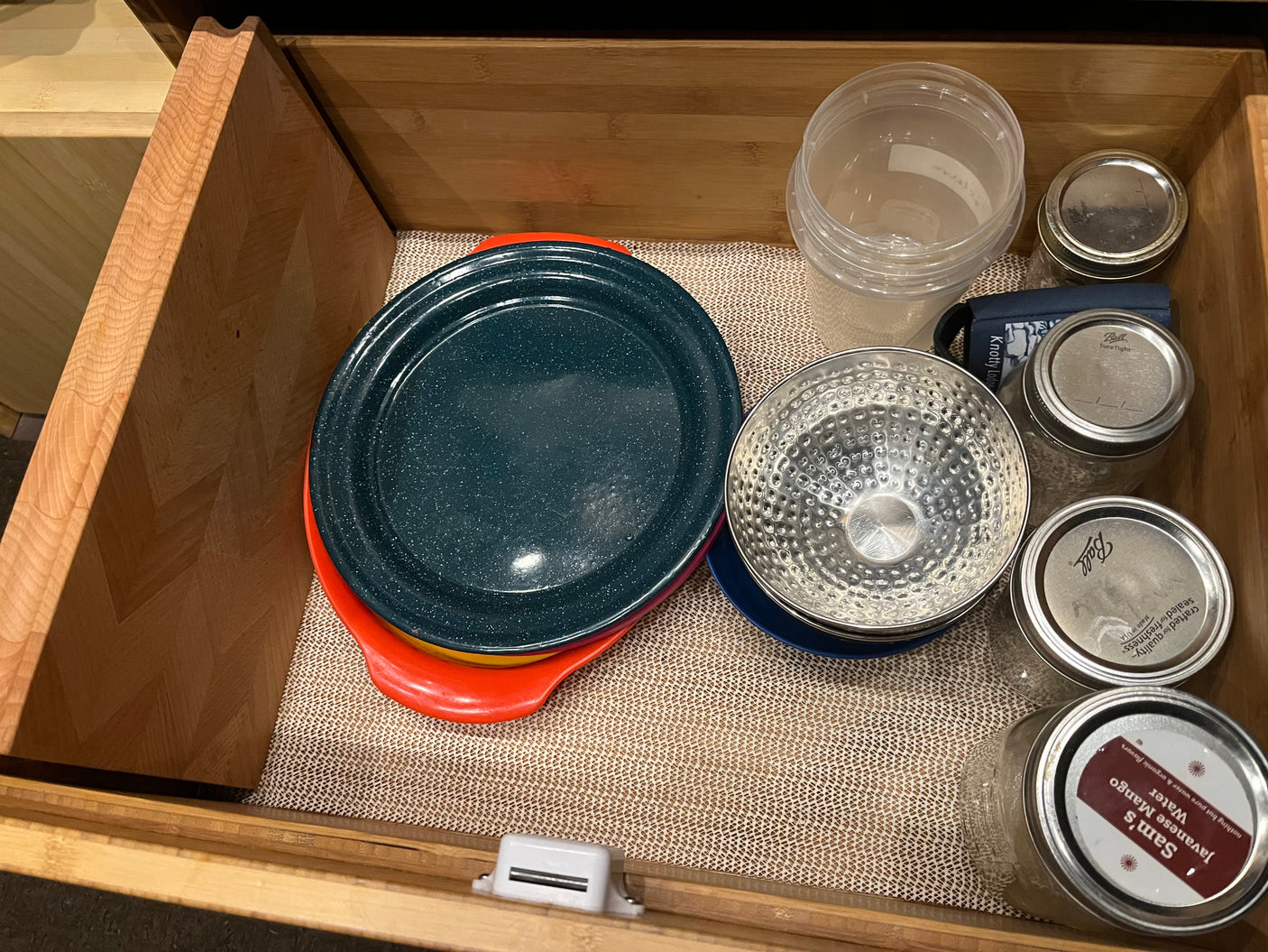 RV rental kitchen drawer with plates, bowls, jars, and cutting board. Optimized storage for travel.