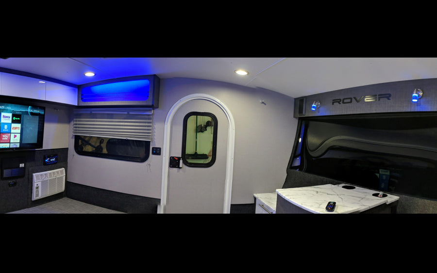 Step inside this modern RV rental! Features include a TV, AC, stylish interior with blue lighting, and a compact design.