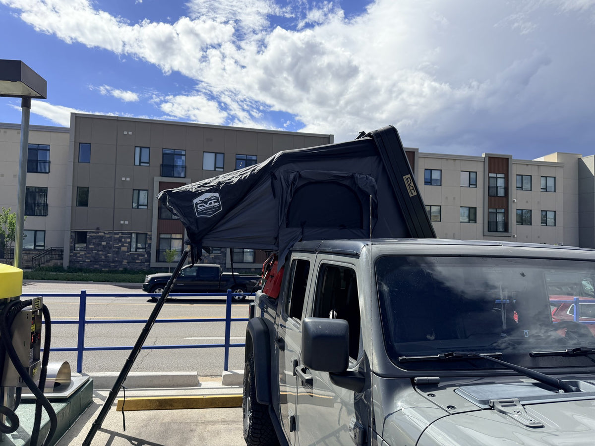 Rooftop tent fully opened on the truck, wide side view with ladder down — photo 2