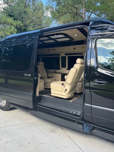 ready for adventure.|Explore this luxury RV rental's spacious interior! The black van has its side door open