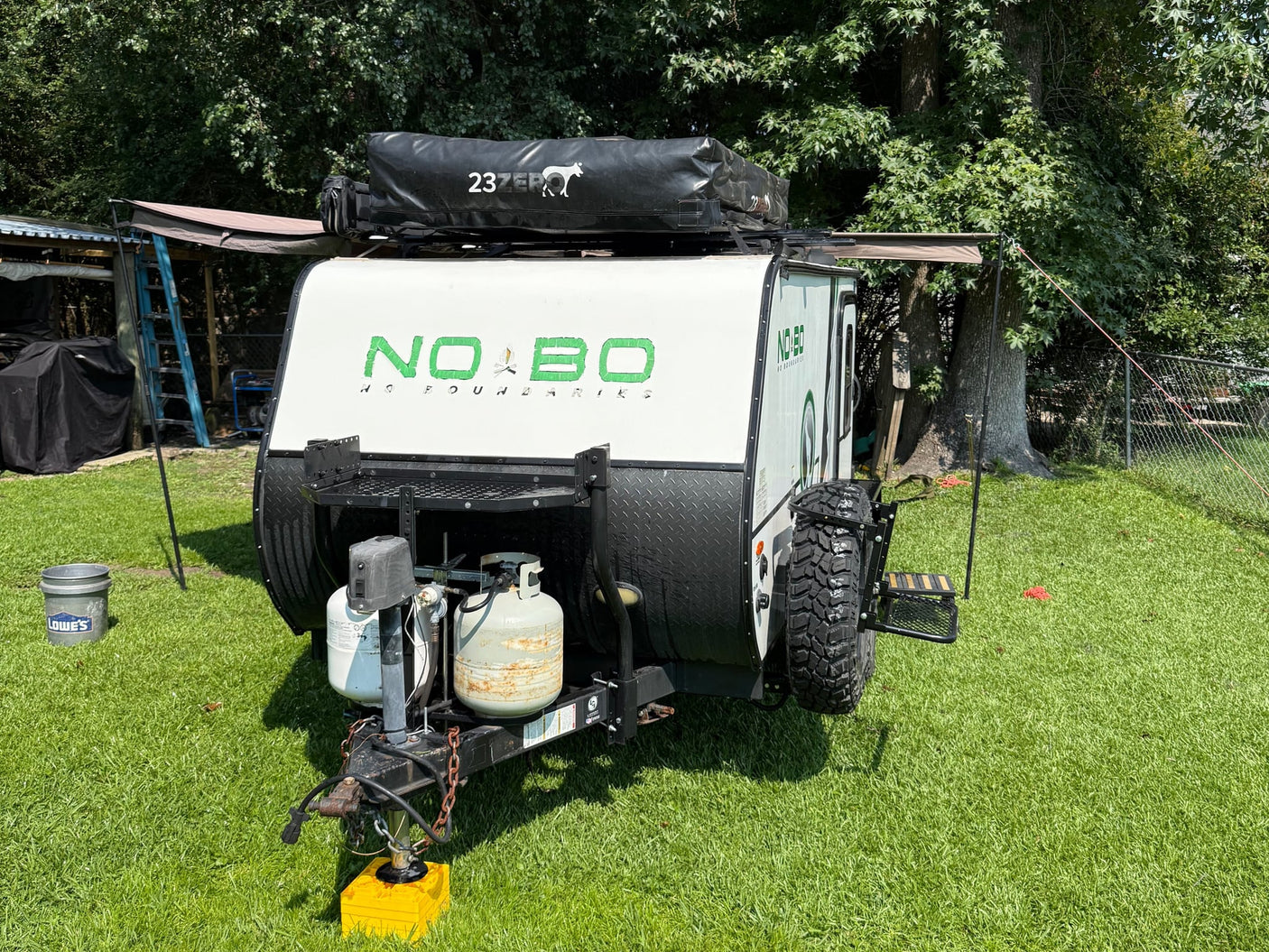 a white NOBO travel trailer with a Rhino-Rack awning