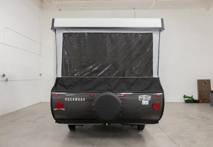 Rear view of a gray Rockwood pop-up RV rental, featuring a spare tire and clear vinyl window on the extended fabric section.