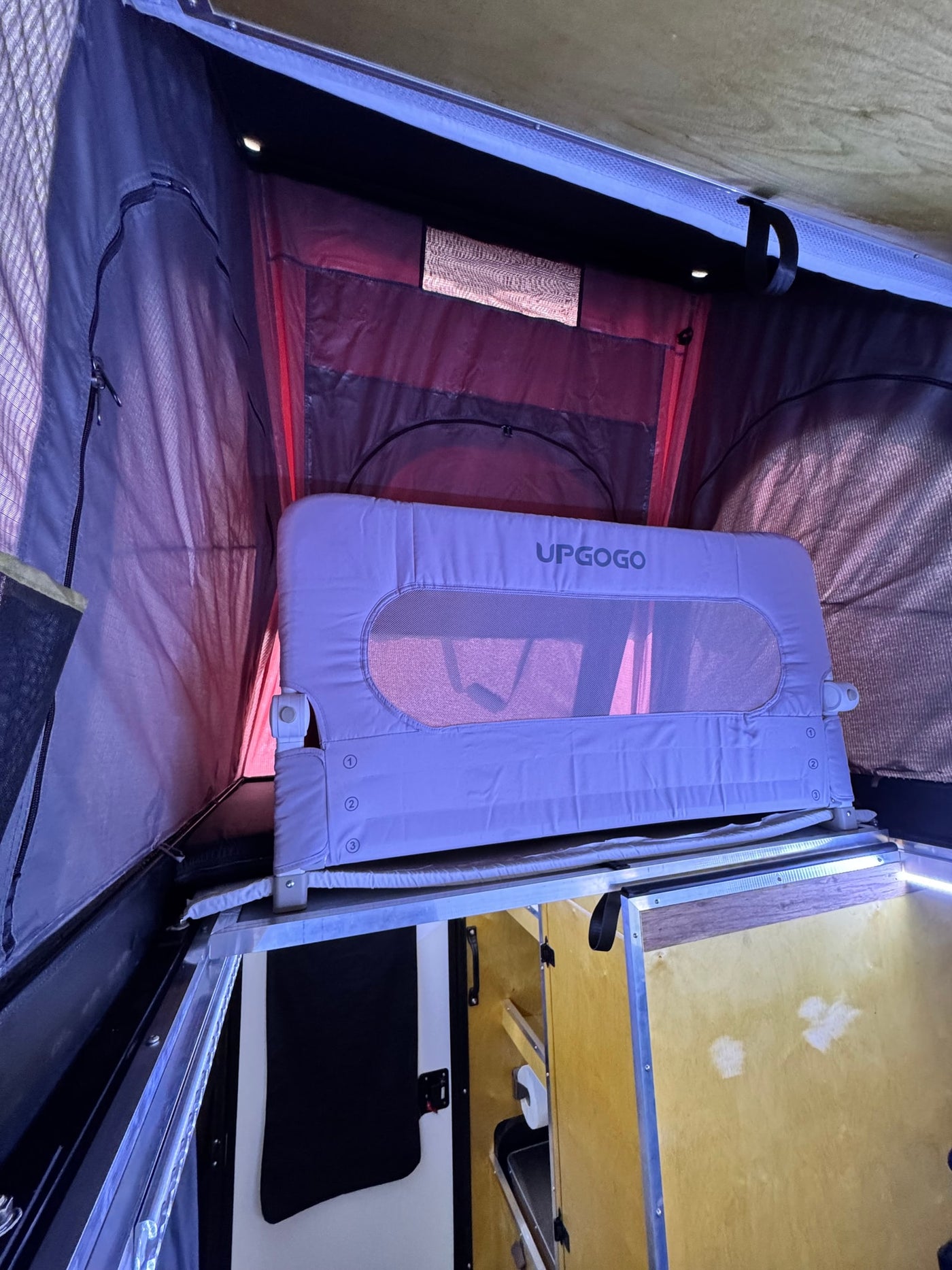 RV rental interior features an UPGOGO child bed rail, ideal for secure sleeping in the camper's pop-top area. — photo 9
