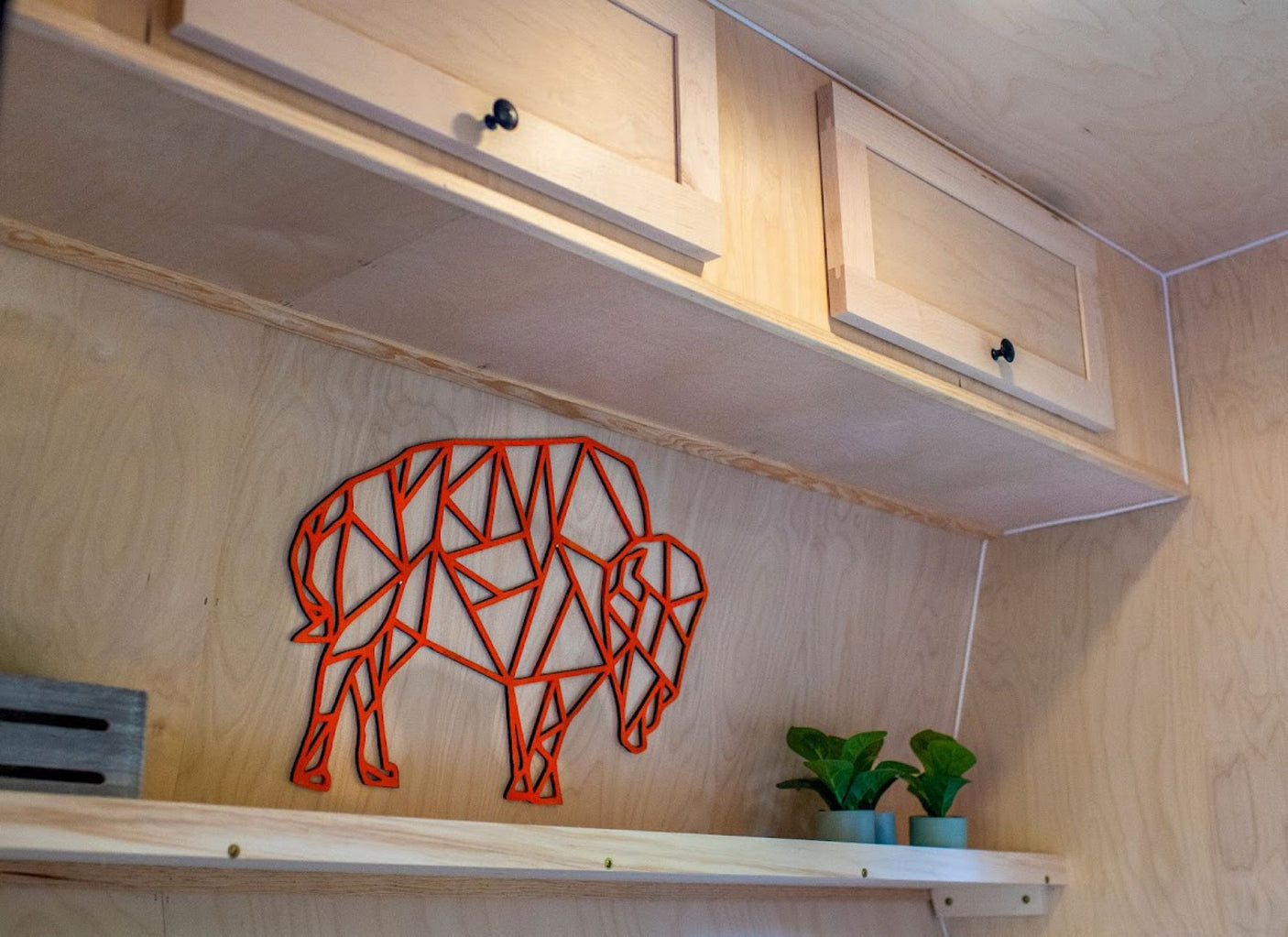 and a "BISON" sign. Ready for adventure cooking.|Cozy rv rental: A young woman sits comfortably reading inside a gray teardrop camper with the door open