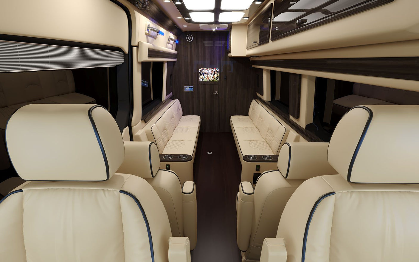 Luxury RV rental interior showcasing cream leather captain's chairs & sofas, dark wood, TV, and ambient lighting.