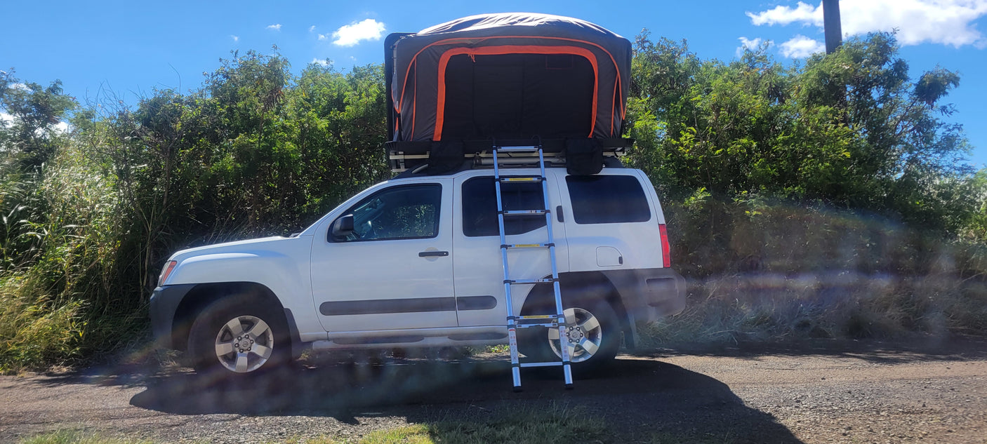 White SUV with a large rooftop tent & ladder, ready for your rv rental camping adventure. Ideal for overlanding!