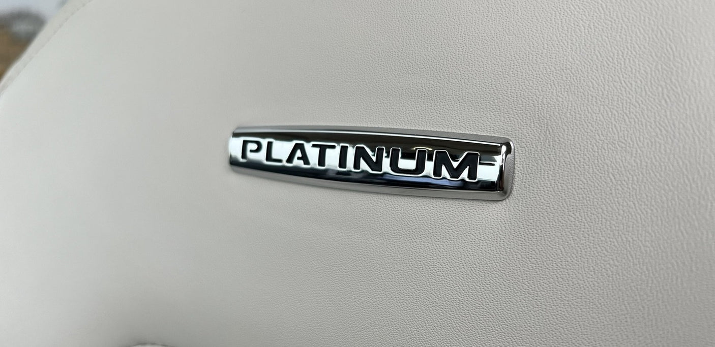 Luxurious 'PLATINUM' emblem on a light, textured interior surface, suggesting a premium rv rental experience.