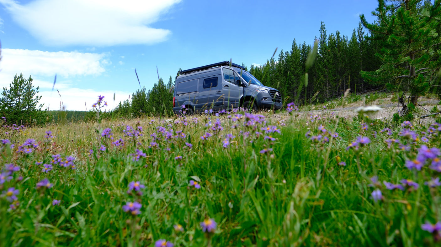 and scenic mountains. Perfect landscape for an RV rental trip.|A dark grey Mercedes Sprinter camper van