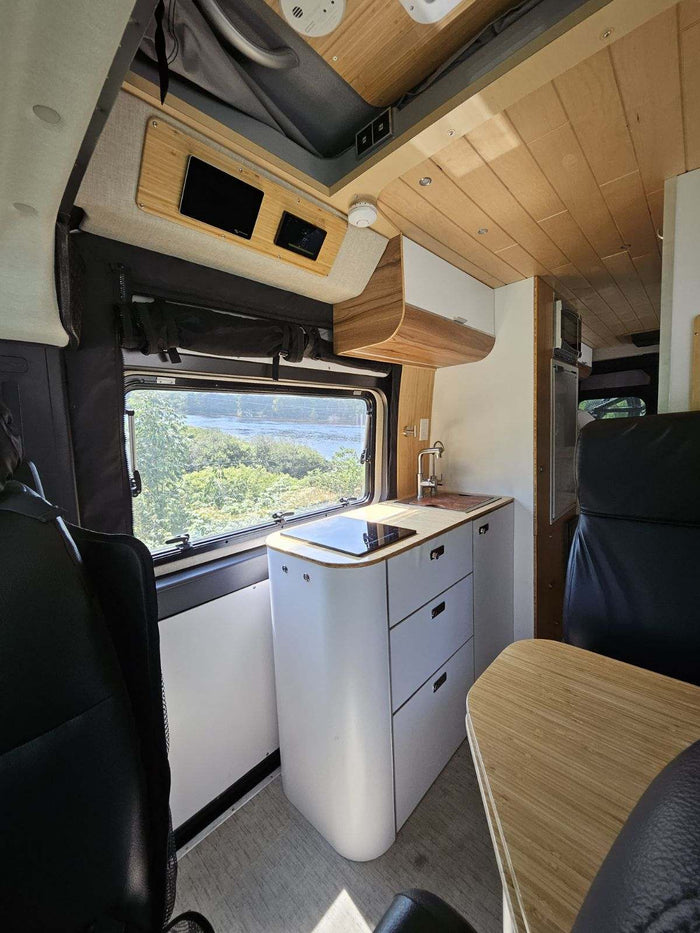 carrying two mountain bikes & spare tire. Ideal for an rv rental adventure!|RV rental ready: Grey camper van with a rear bike rack holding two mountain bikes