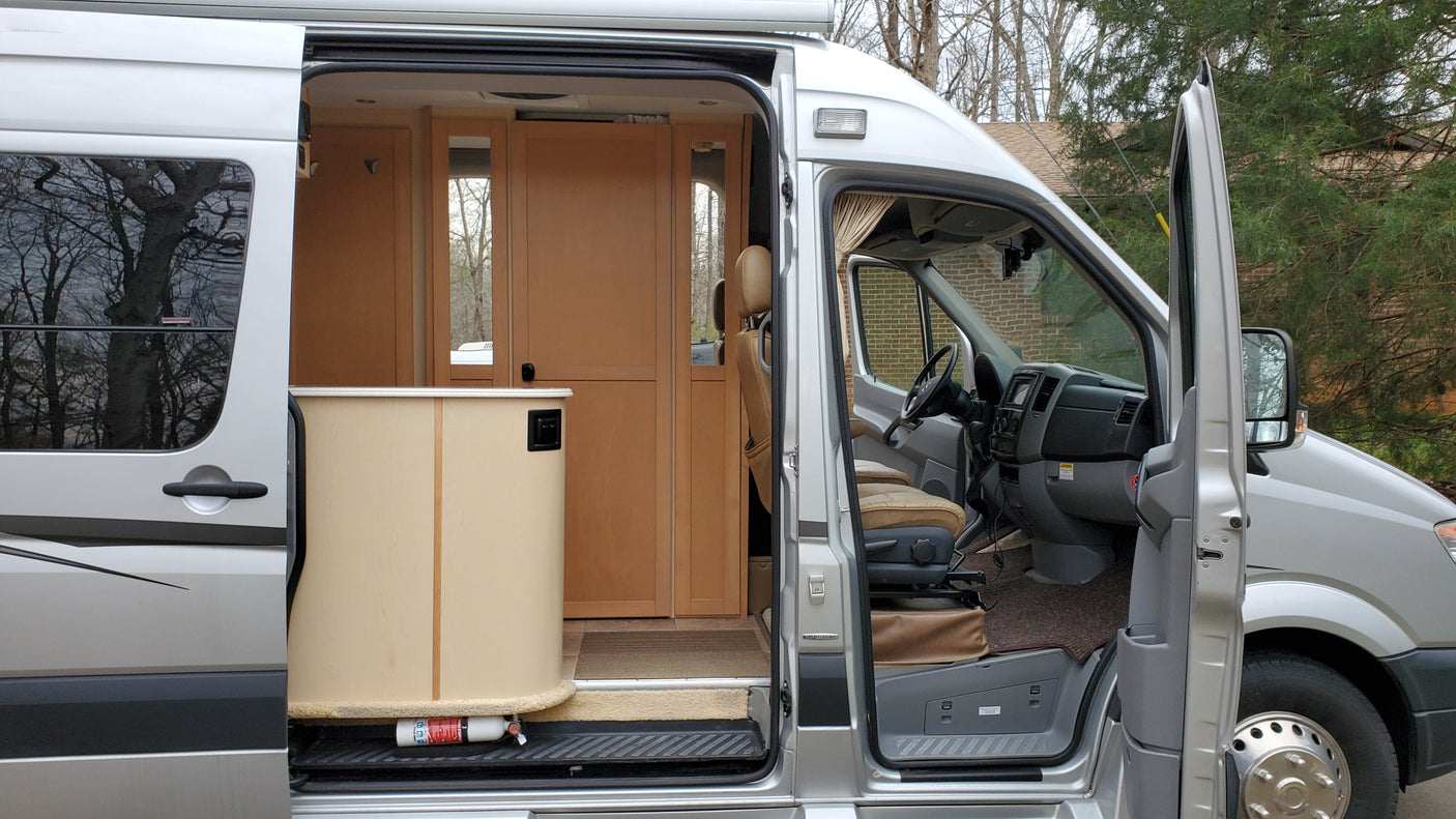 Explore this spacious RV rental interior, a Mercedes Sprinter camper van with open doors, ready for adventure.