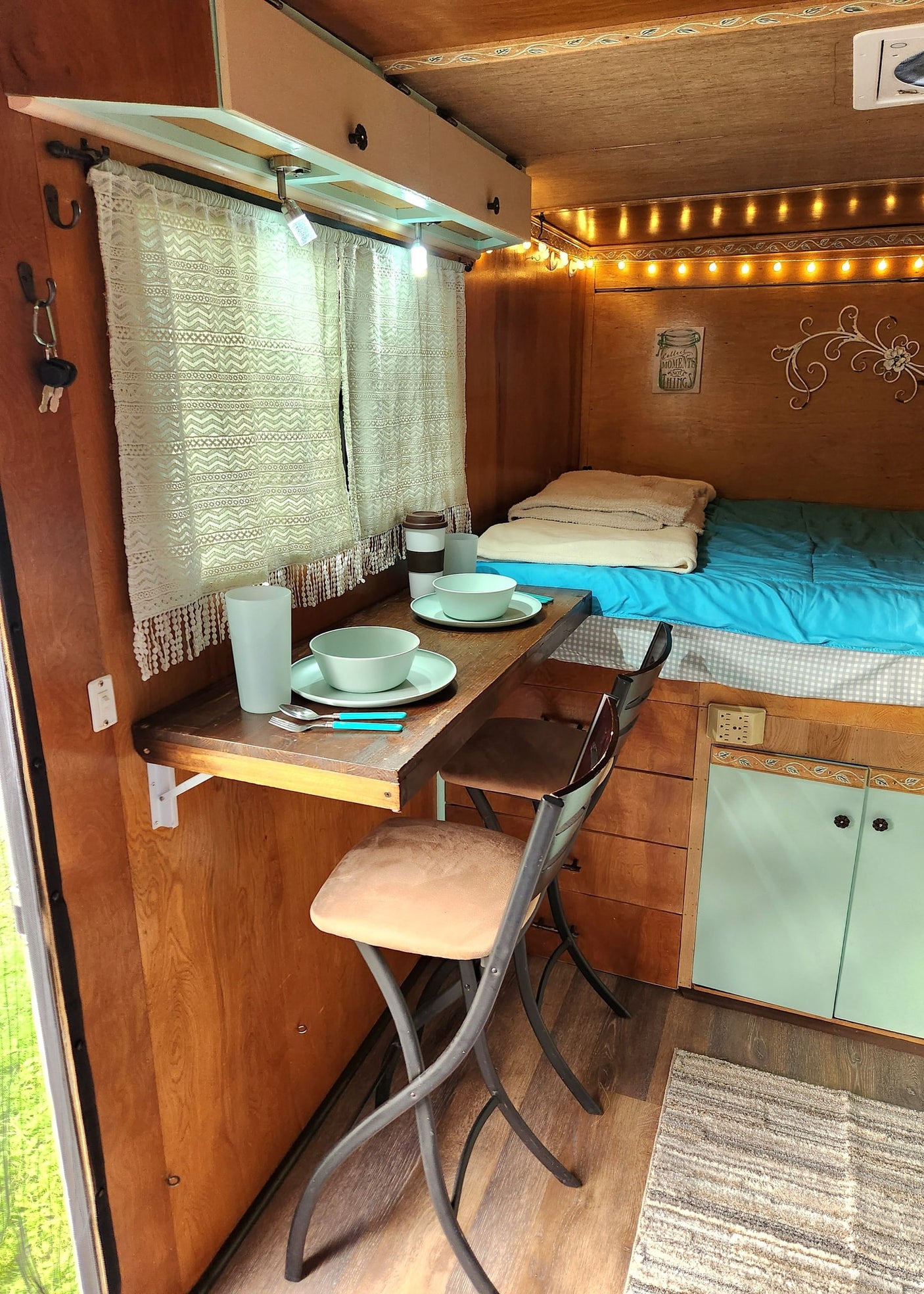 a cargo trailer converted with bunk beds and smart storage for your next adventure.|Cozy RV rental interior featuring comfortable bunk beds with blue bedding