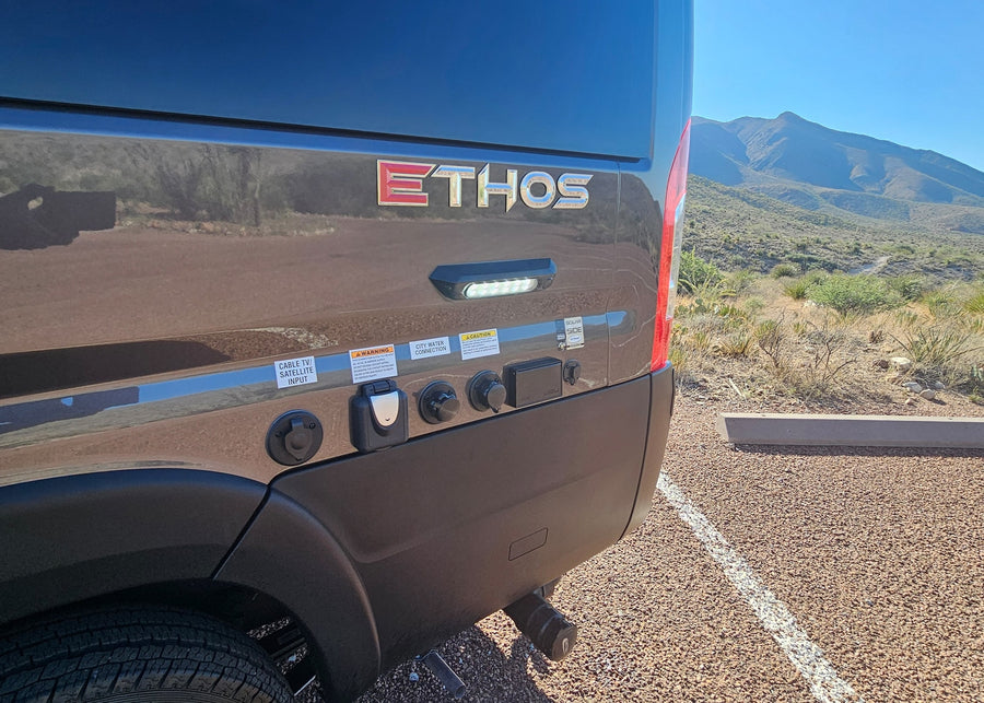 featuring a Thule awning. An ideal RV rental for your next outdoor adventure.|Modern Ethos RV rental with utility hookups parked in a sunny desert landscape