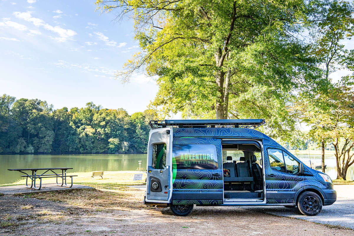 perfect for an RV rental adventure with built-in bike storage.|Spacious RV rental camper van with side door open