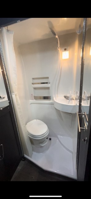 and "Handicapped Parking" sign. Mobile office by the ocean.|Relaxing RV rental interior showing a cozy bed and ocean view through the windows. Ideal beachfront camping.|Dark gray camper van — photo 8
