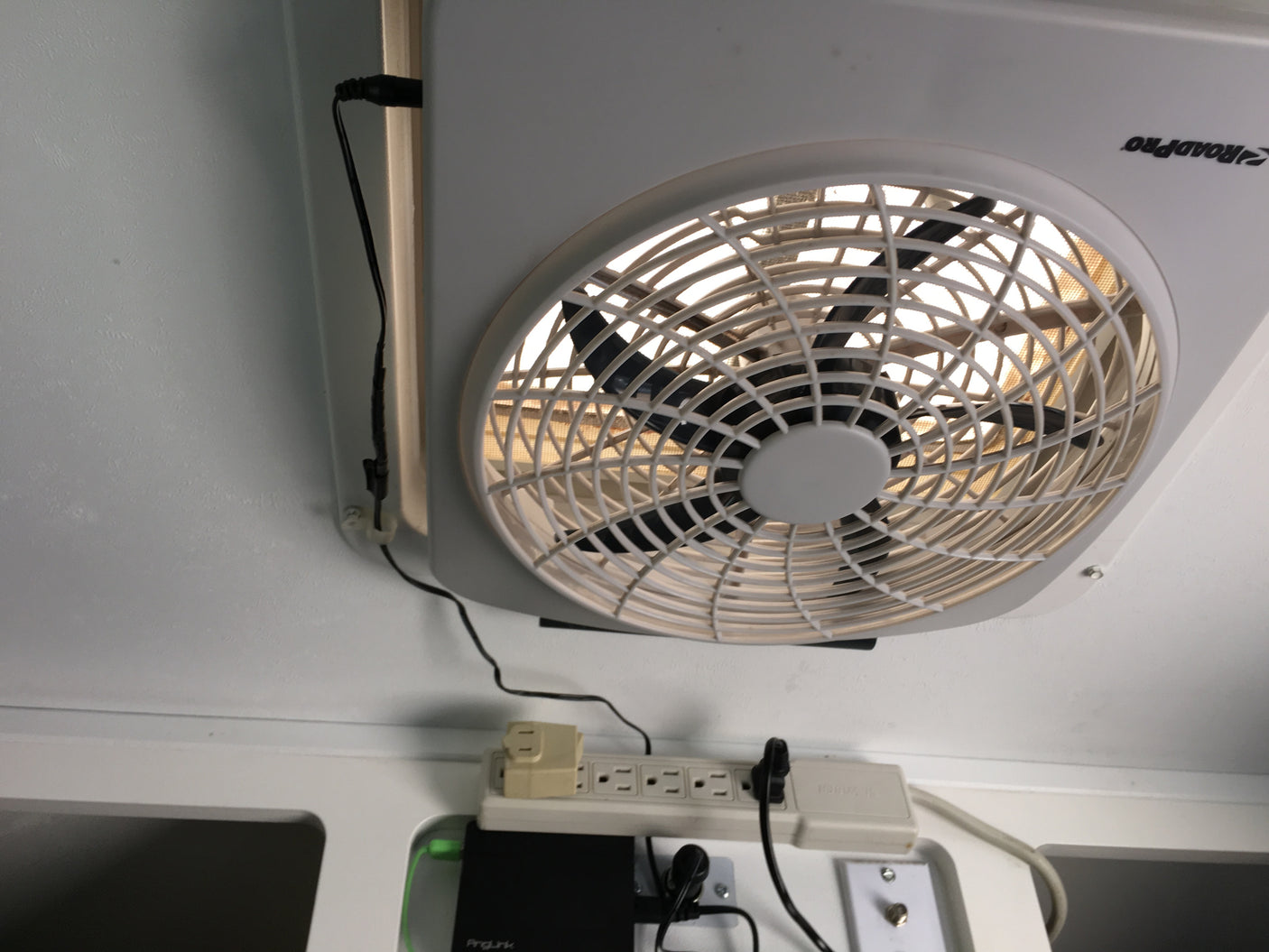 RV rental ceiling fan, power strip, and electronics are seen, providing comfort and connectivity in a compact space.