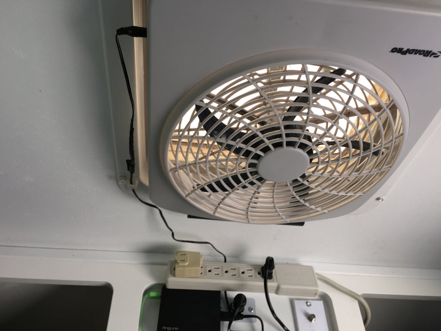 RV rental ceiling fan, power strip, and electronics are seen, providing comfort and connectivity in a compact space.