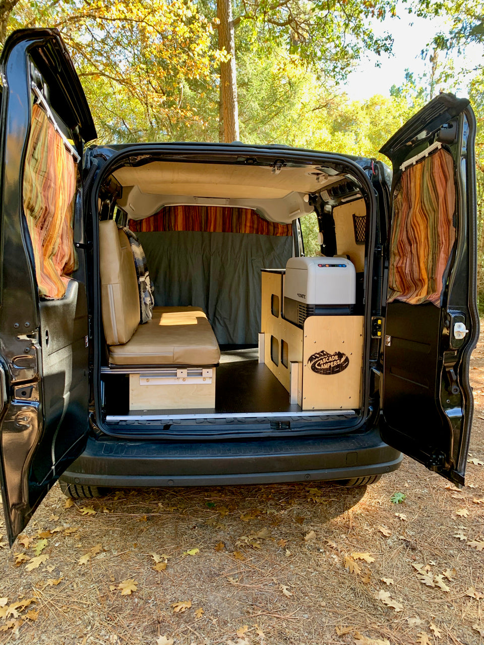 Inside an RV rental camper van conversion: custom interior with bed, fridge, and storage, ready for adventure.