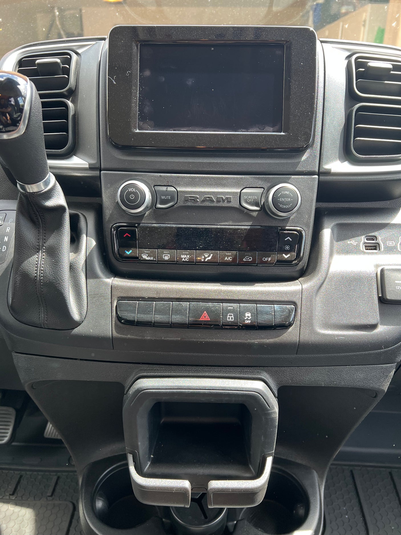 Up-close view of an RV rental's dashboard, featuring infotainment, gear shift, climate, and other vehicle controls.