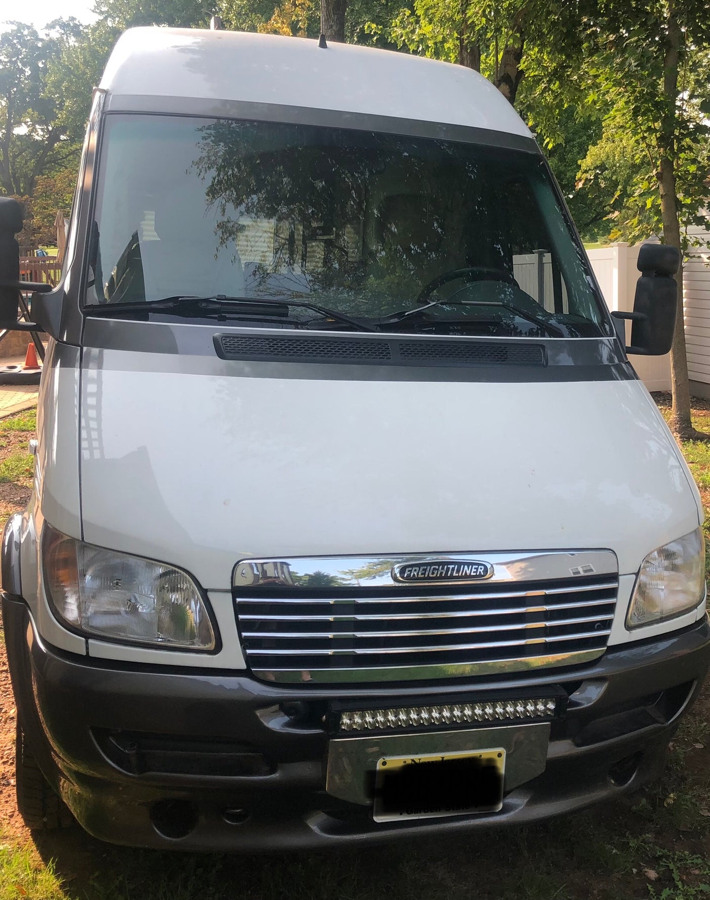 Front view of a white Freightliner Sprinter van, perfect for rv rental. This camper conversion is ready for adventure.