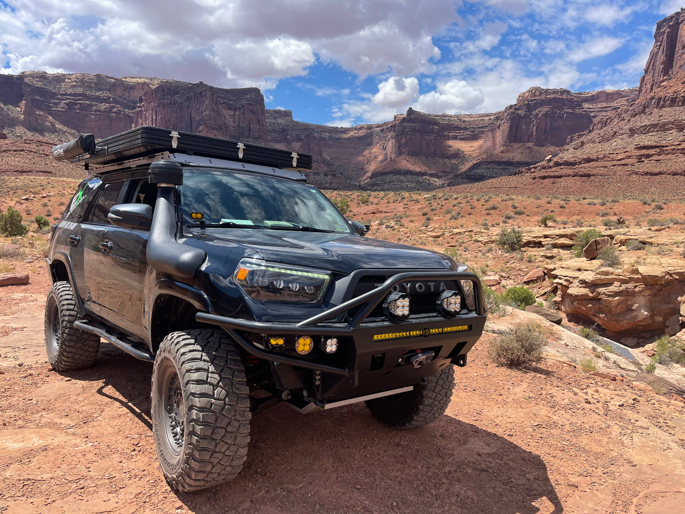 Modified Toyota 4Runner with rooftop tent & snorkel in a desert landscape, ideal for an **rv rental** adventure.