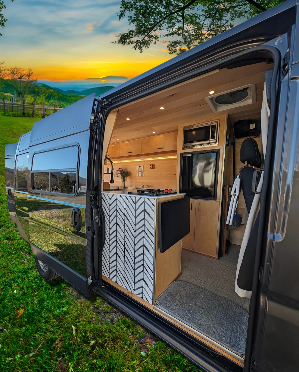 Experience RV rental luxury! This custom van features a modern kitchen, cozy interior, and scenic mountain views at sunset.