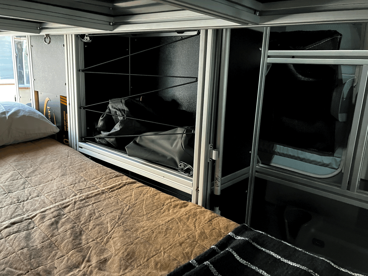 RV rental interior features modular storage, a cozy sleeping area, and power systems for comfort on the go.