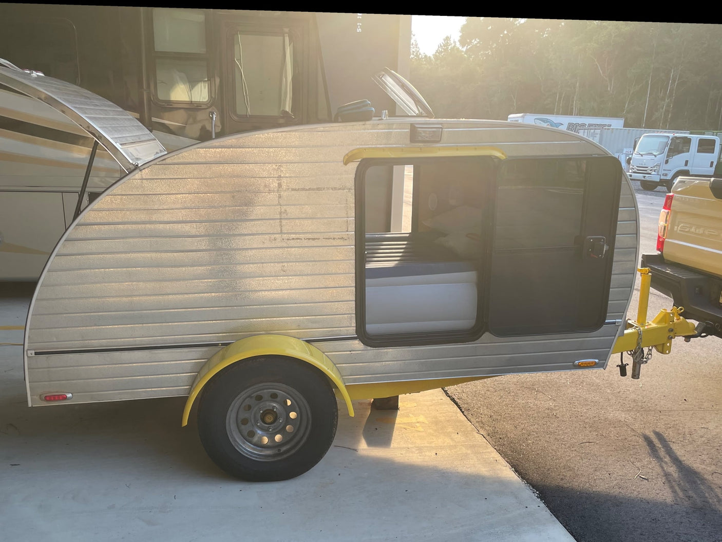 offering fresh air.|Cozy RV rental sleeping area with an inflatable air mattress & white-wrapped pillows