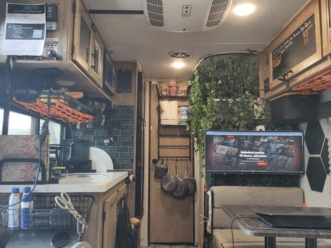 and a space-saving corner sink.|Modern RV rental shower featuring black rainfall head