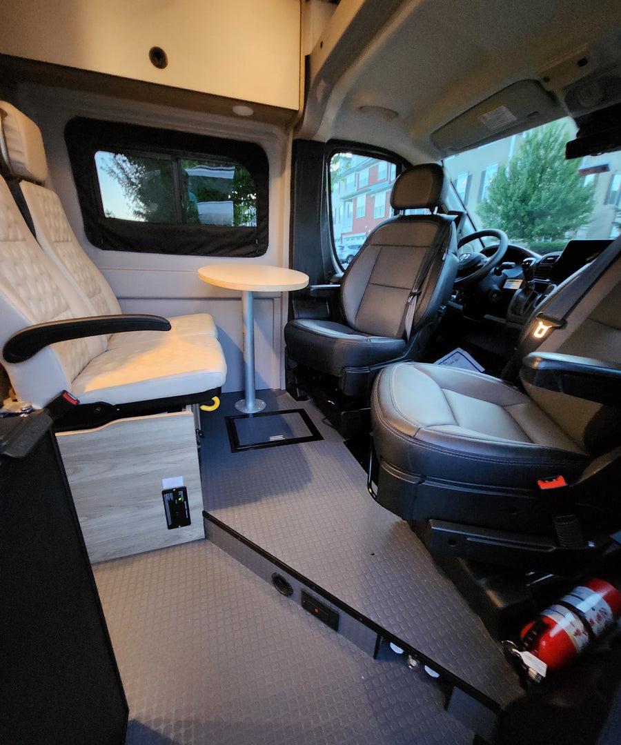 quilted rear living area.|Interior of an RV rental showing the driver's cabin with swiveling seats