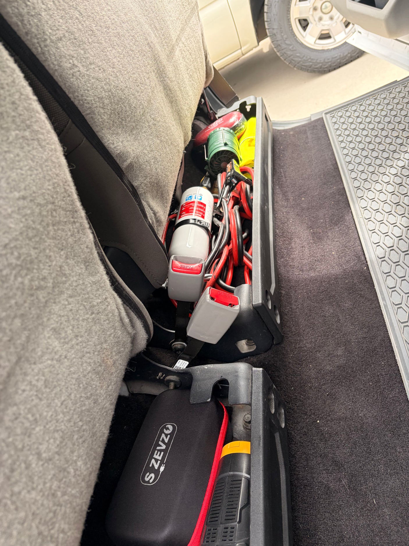 RV rental emergency kit: Jumper cables, fire extinguisher, and flashlight are neatly stored behind the vehicle's seat.