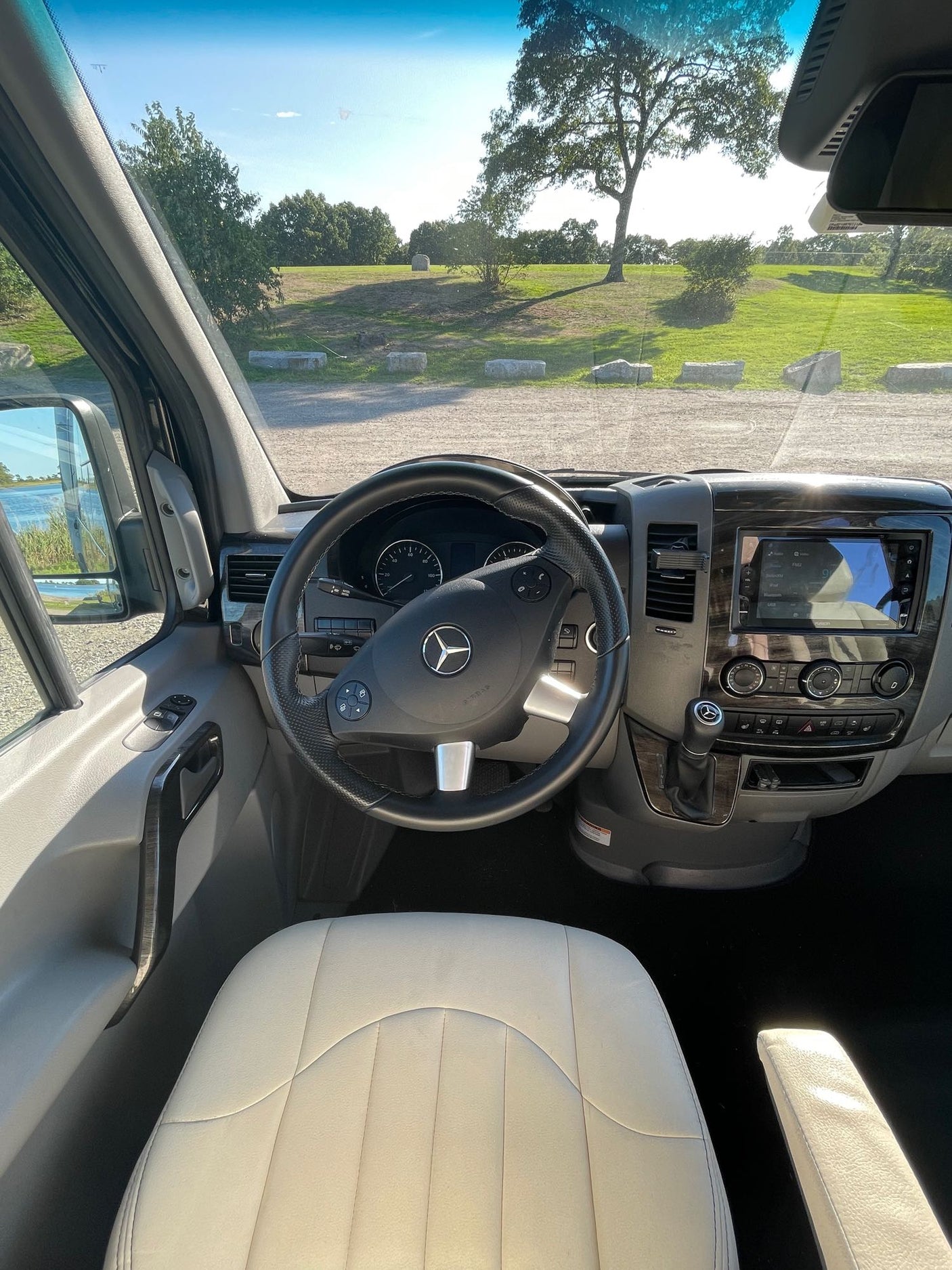 and large windows revealing scenic views.|Modern RV rental interior with compact kitchen