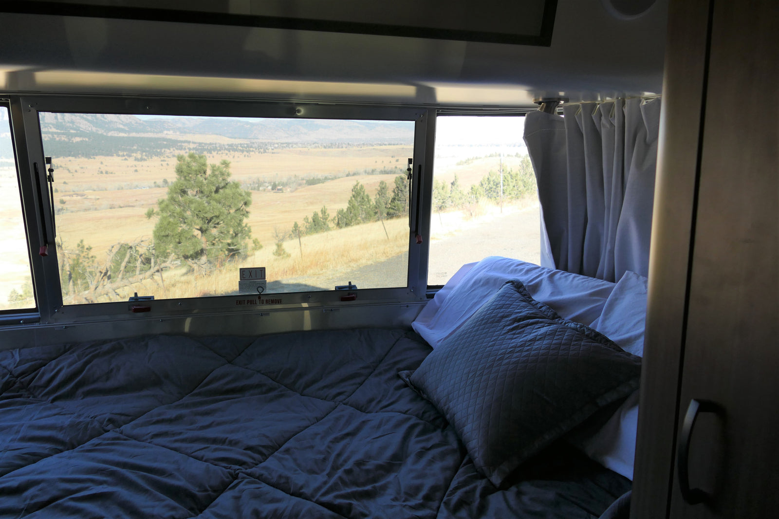 Cozy RV rental bedroom offering a stunning landscape view through the window. Experience comfort and nature on your travels.
