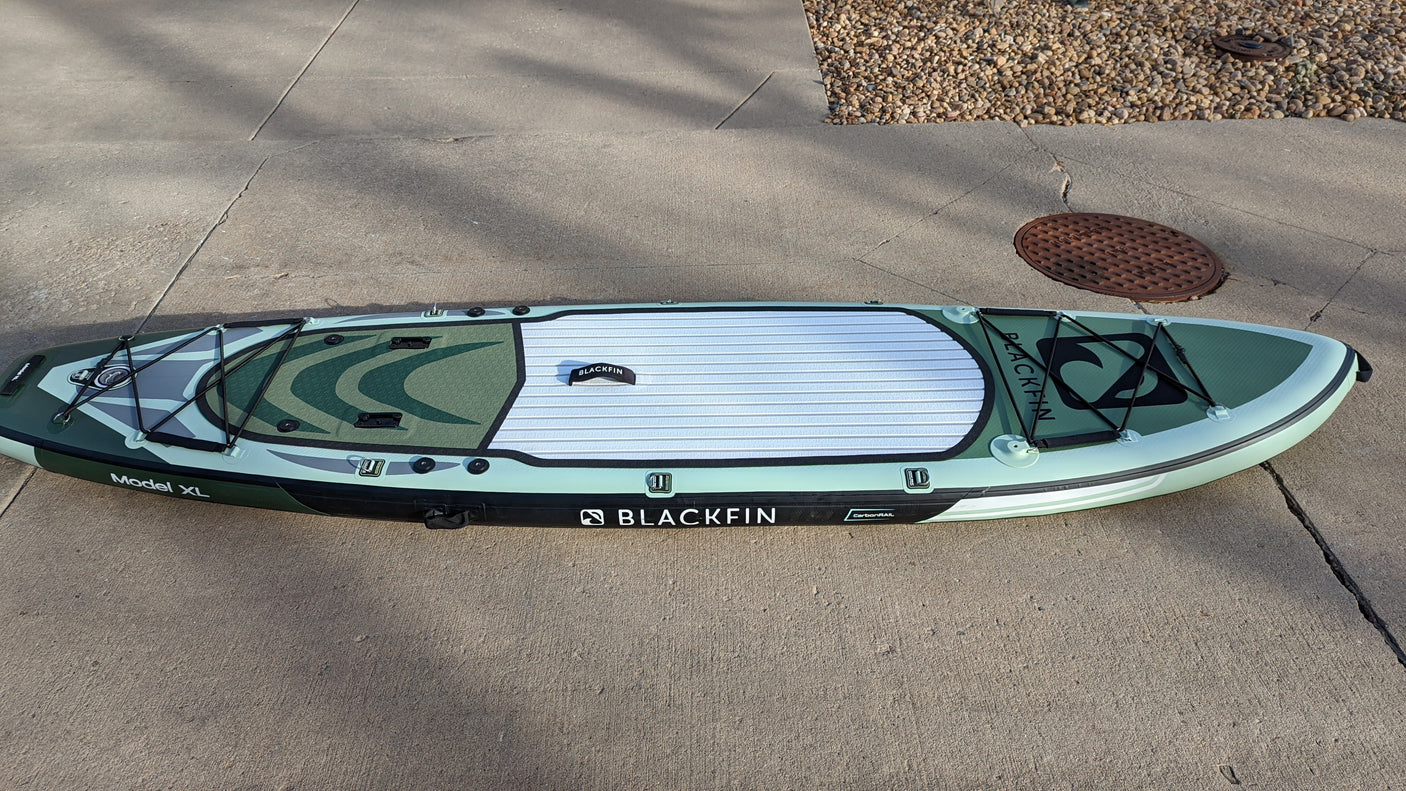 This green Blackfin Model XL inflatable paddleboard on concrete is ready for RV rental travel and water adventures.