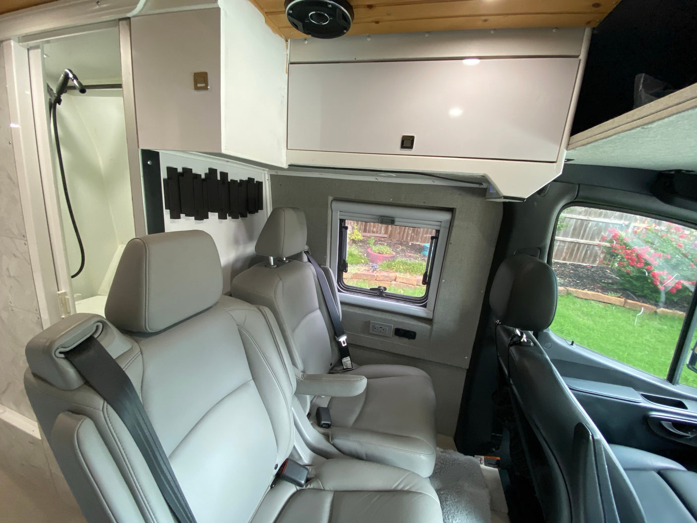 and a wooden cutting board covering the sink on a light counter.|This RV rental features a compact
