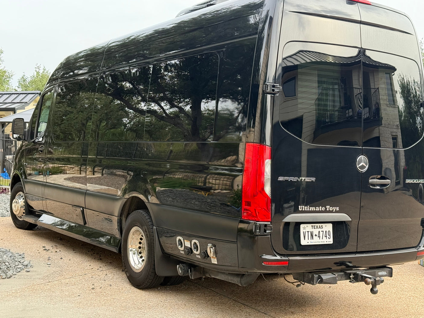 This black Mercedes-Benz Sprinter 'Ultimate Toys' luxury RV rental van boasts dually wheels & rear hookups.