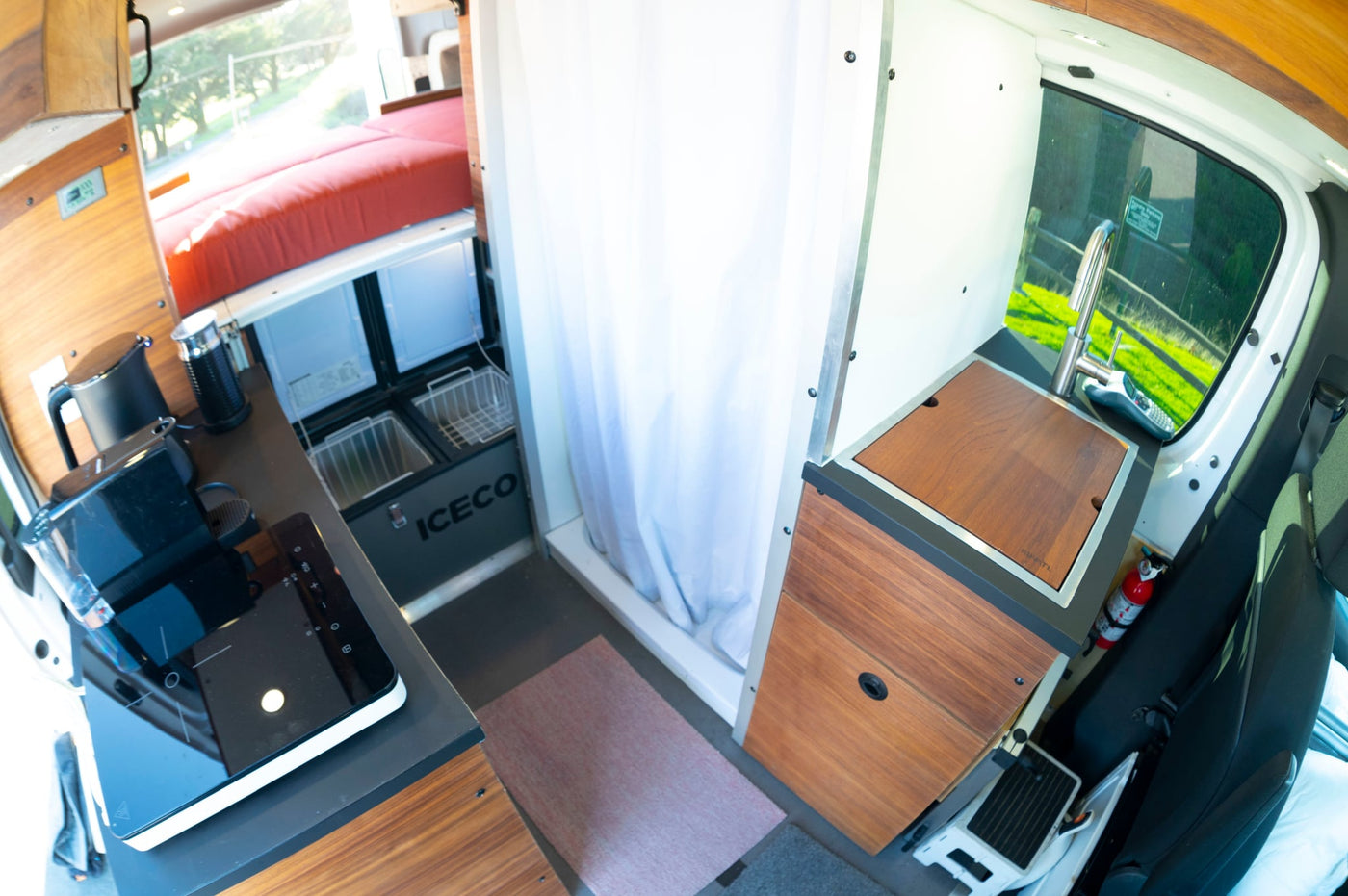 and storage shelves.|Modern RV rental interior: sleek kitchen with cooktop — photo 11