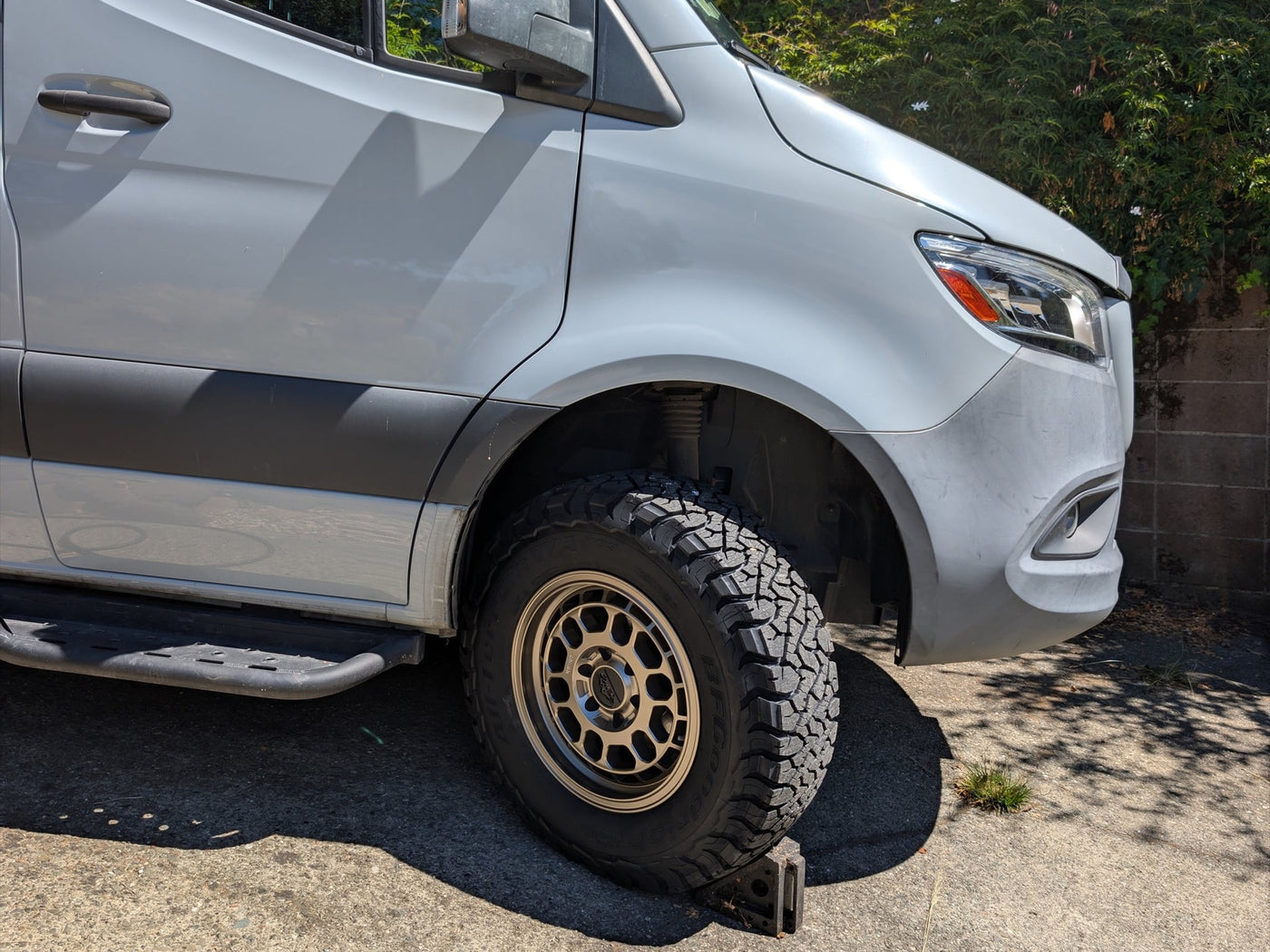 equipped with rugged off-road tires and bronze aftermarket wheels — photo 3