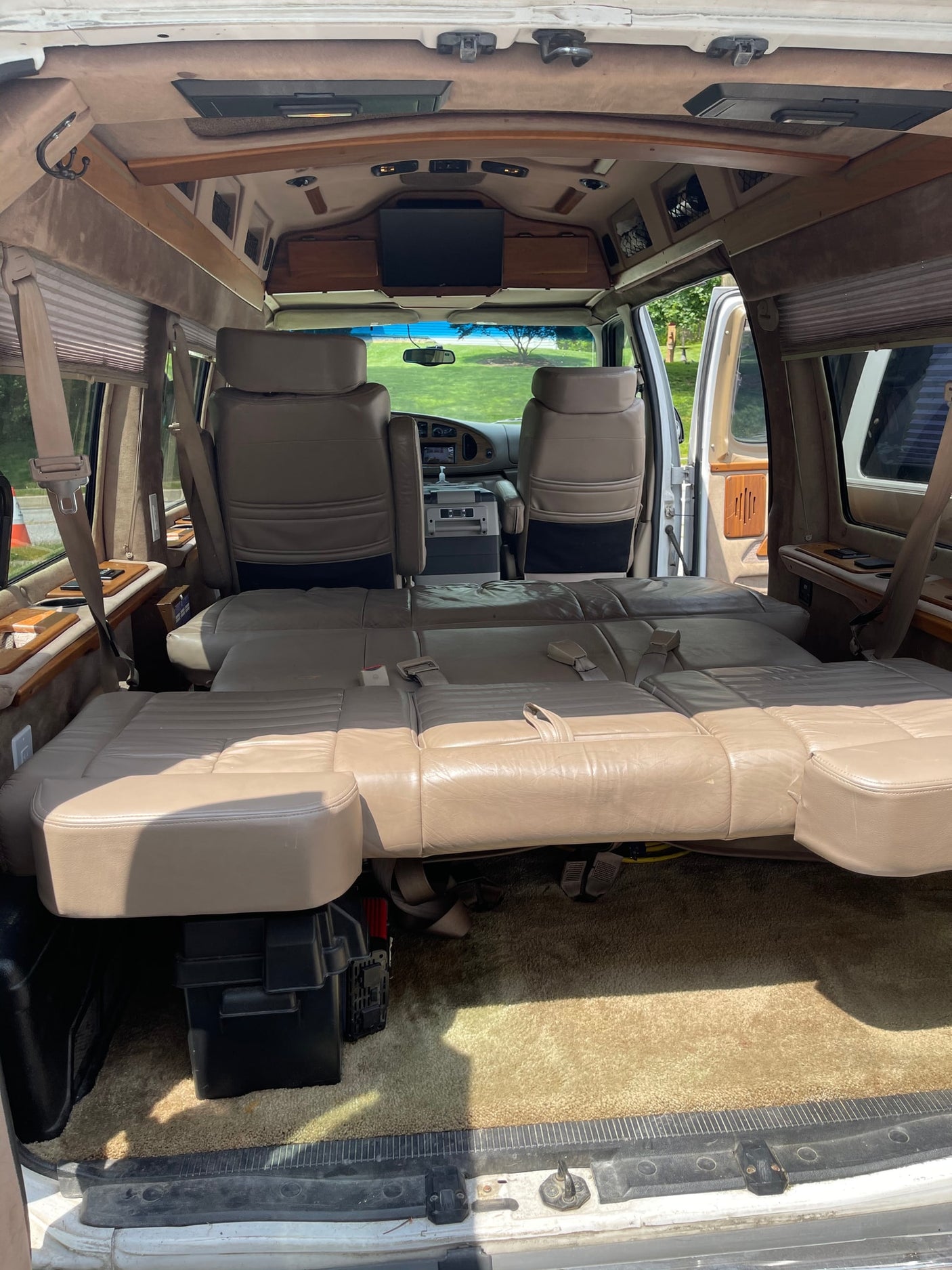 charging via wall outlet in the carpeted interior.|Inside an rv rental: dashboard with a Pioneer backup camera displaying caution