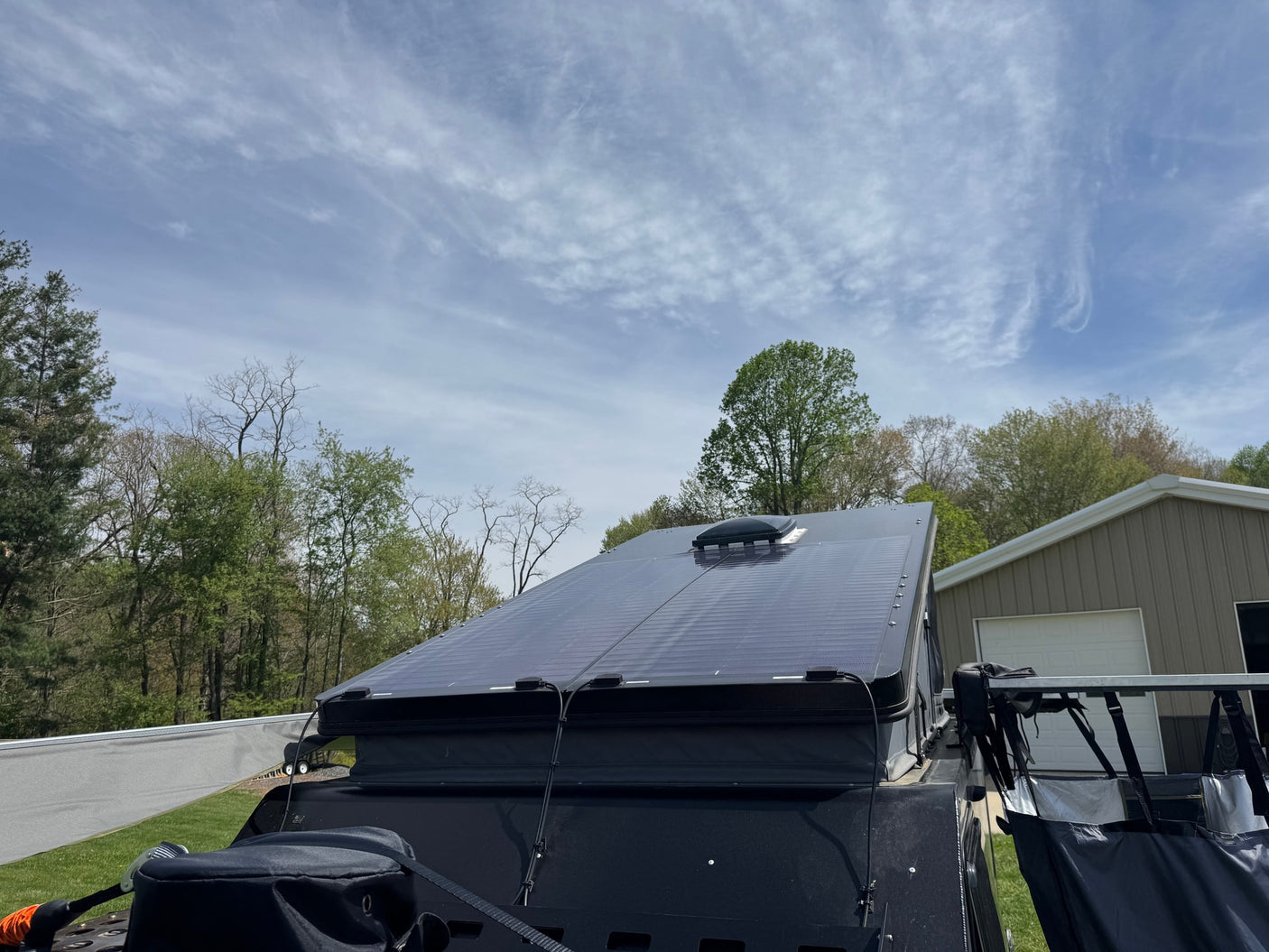 Top view of an RV rental with sleek solar panels on the roof, ready for off-grid excursions under a partly cloudy sky.