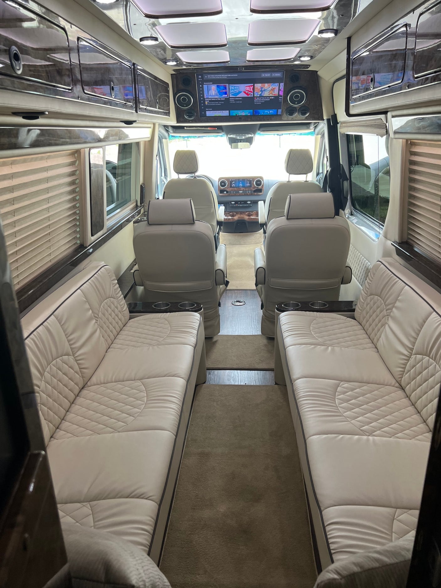 custom lighting for comfortable travel.|Luxury RV rental interior with plush white seating