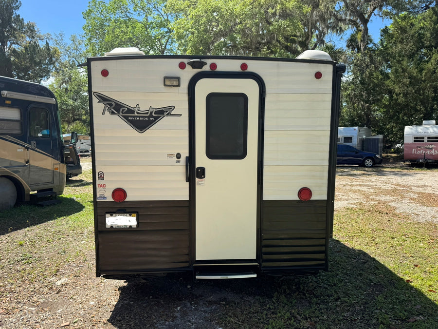 parked outdoors.|A white and black Retro travel trailer