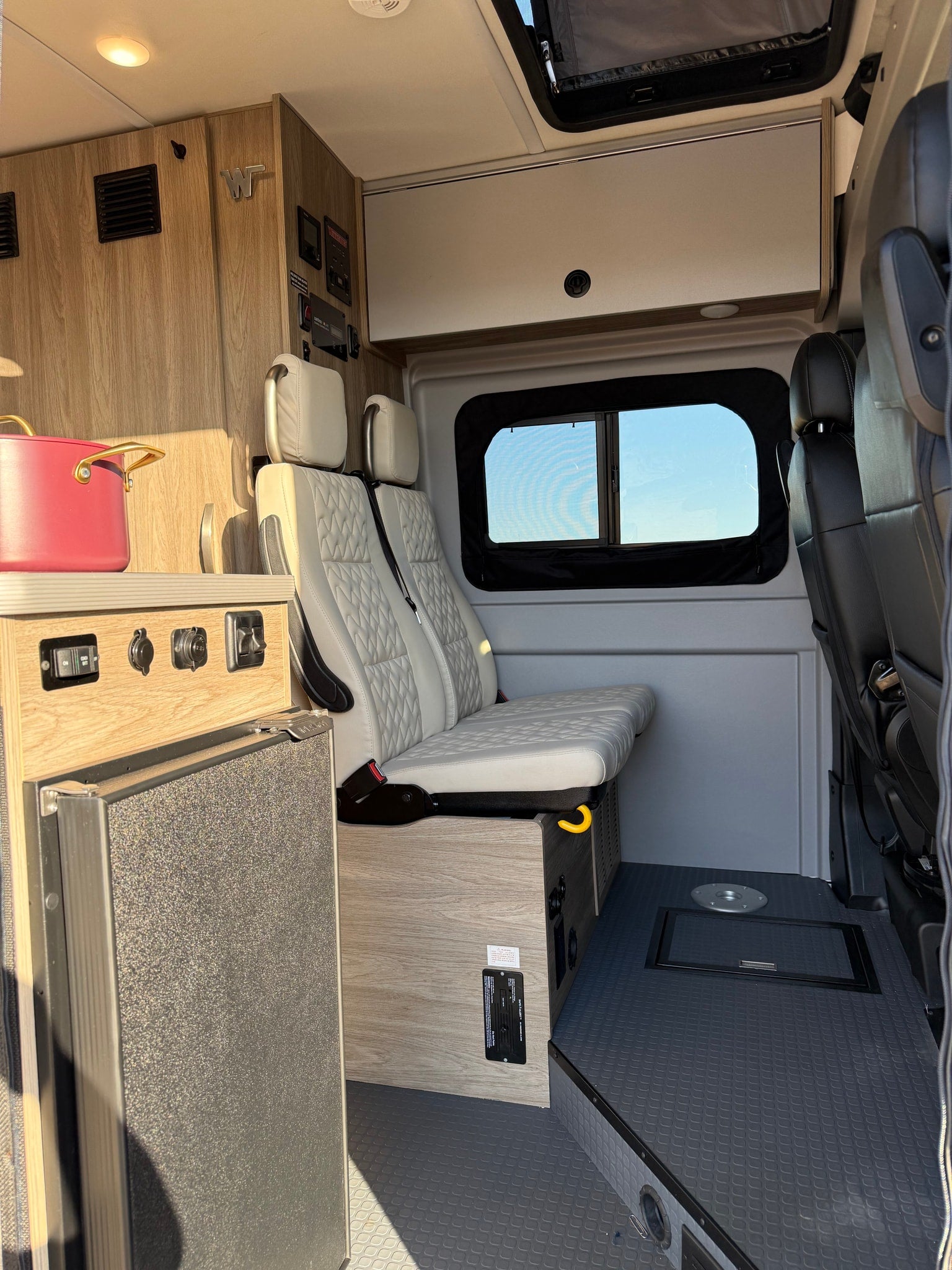 and two chairs set for relaxation.|Cozy Winnebago RV rental interior with quilted seats