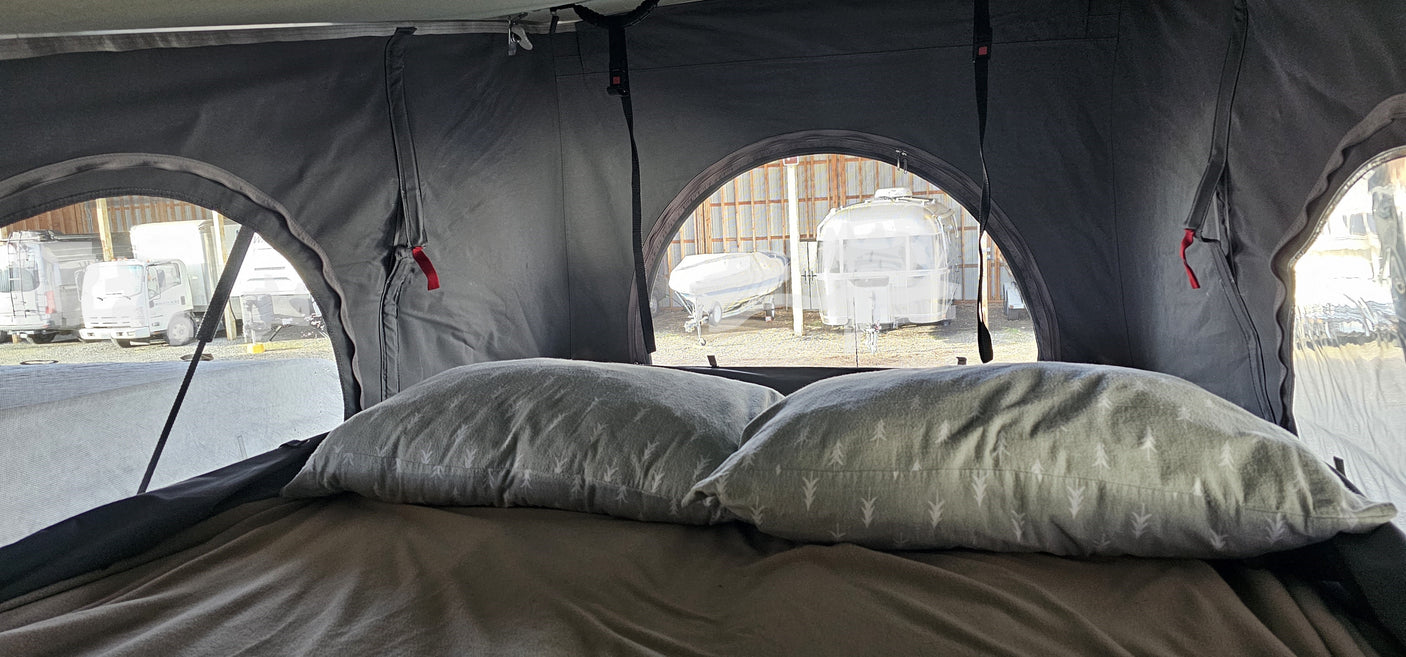 Cozy view from an RV rental, overlooking a storage lot with a truck, boat, and Airstream travel trailer.