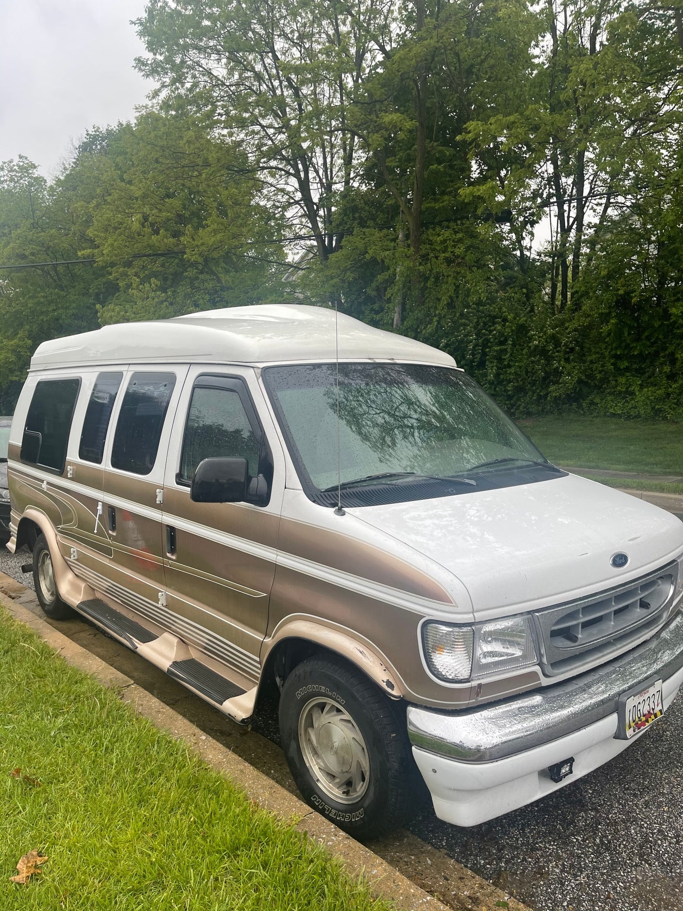White and gold Ford conversion van